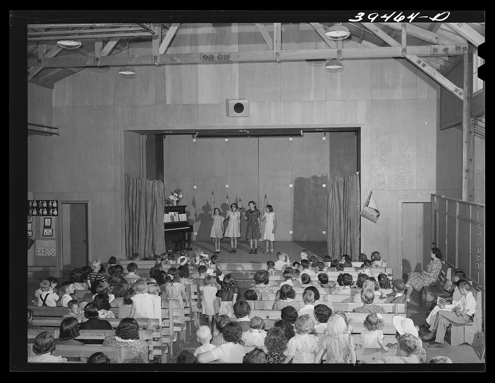 FSA (Farm Security Administration) labor camp. Children watching their schoolmates in a program at the end of the school…