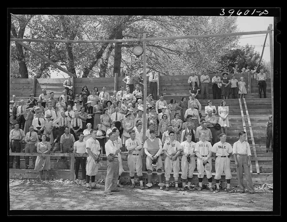 Baseball players and spectators stand at attention while Chief Justice Stone gives the oath of allegiance over the radio.…