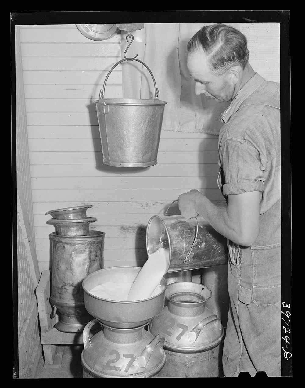 Pouring milk into cans. Farm of member of the Dairymen's Cooperative Creamery. Caldwell, Canyon County, Idaho by Russell Lee