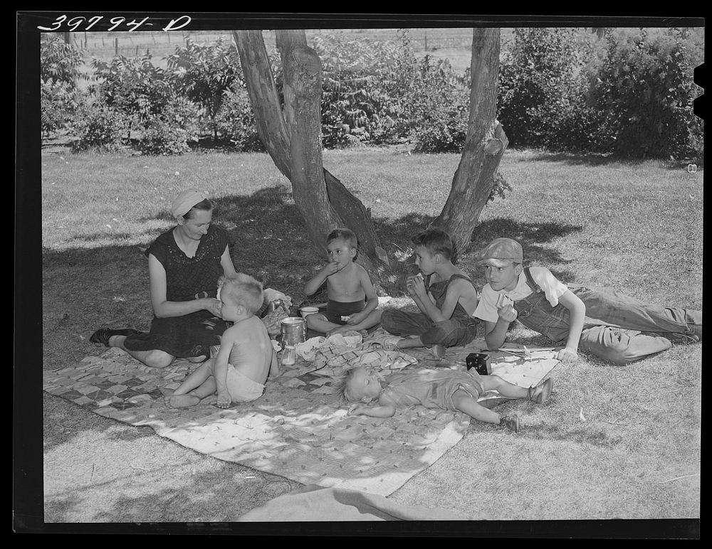 Farm workers who live in the FSA (Farm Security Administration) migratory farm labor camp mobile unit  picnic in nearby…