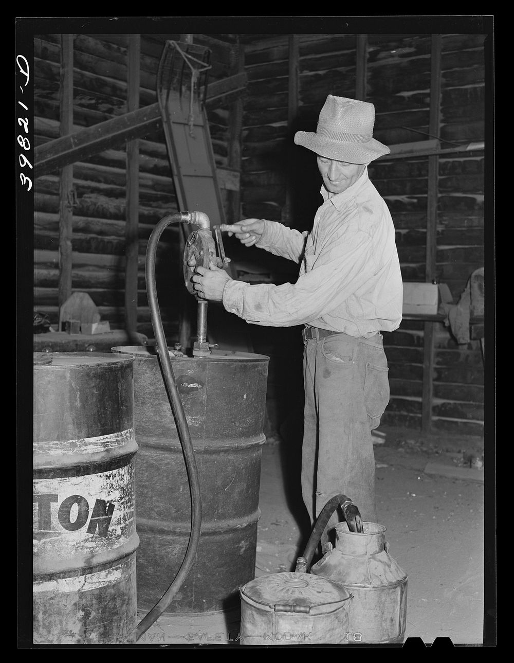 Getting gasoline from barrel at farm to take out to combine in the wheat field. Walla Walla County, Washington by Russell Lee