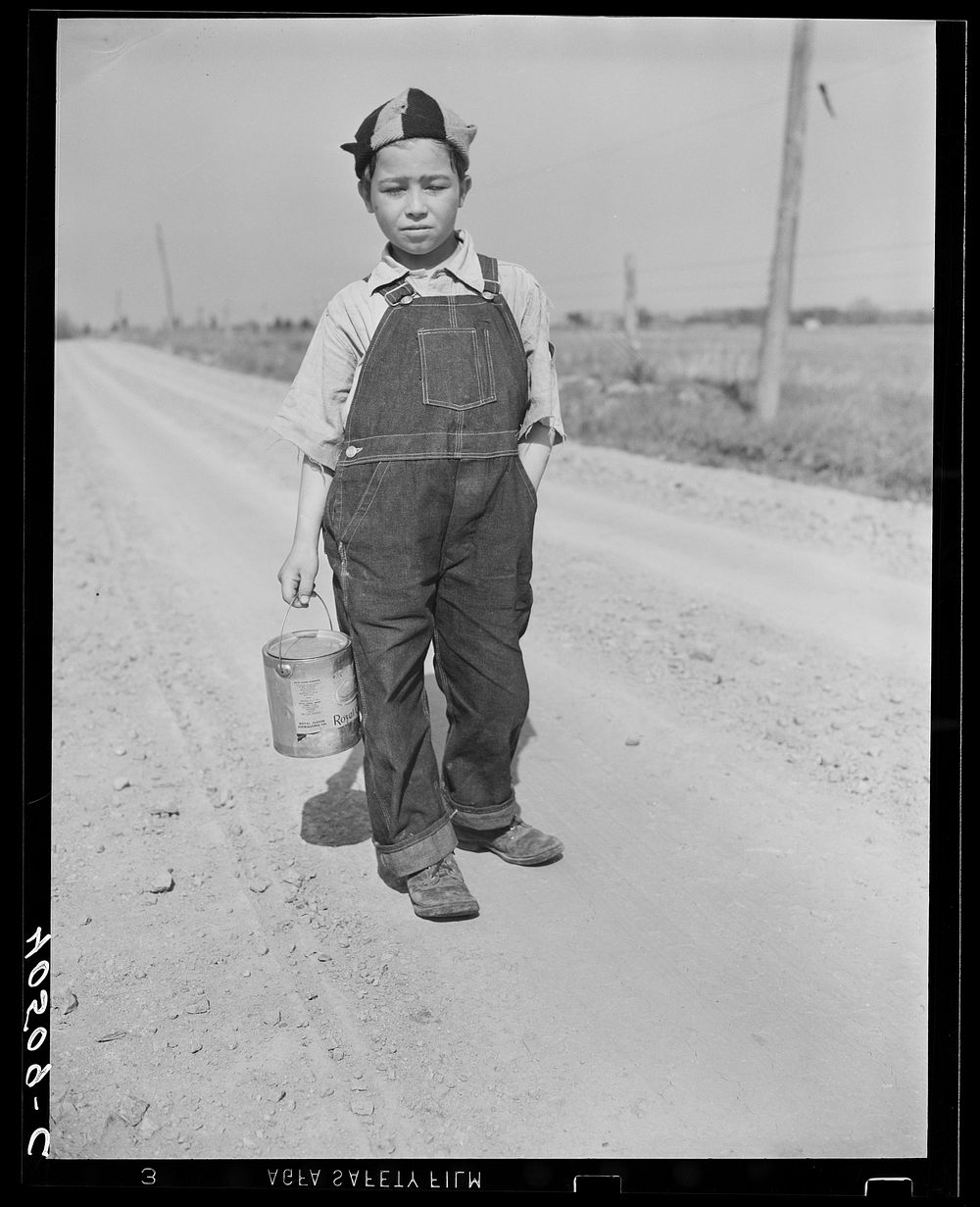 Boy on way home from school. Can contains his lunch. Near Sterling, Virginia. Sourced from the Library of Congress.