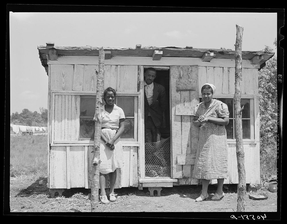 Burdell White, FSA (Farm Security Administration) client, his wife and daughter standing beside their new chicken coop…