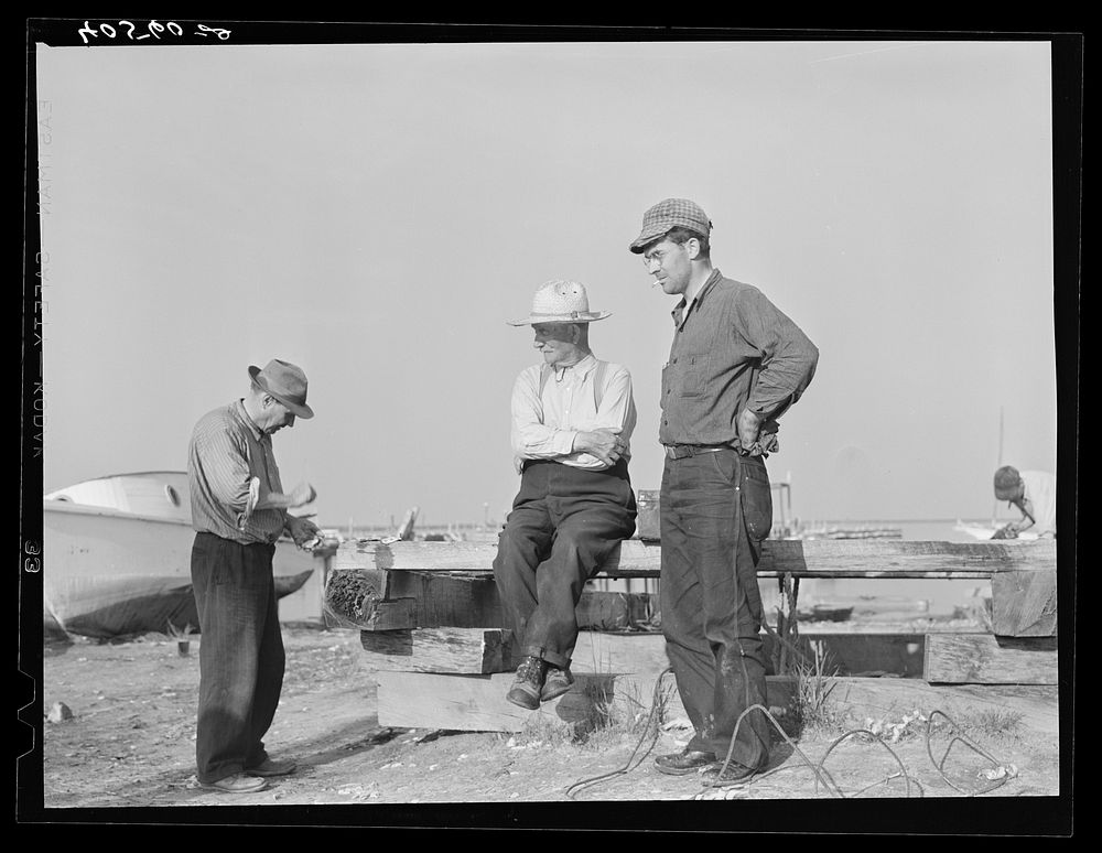 Deal Island fisherman. Man on left is opening an oyster. Eastern Shore, Maryland. Sourced from the Library of Congress.
