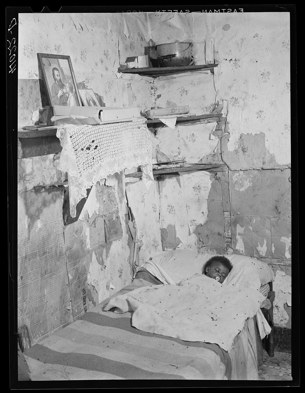 The interior of the home of Edward Gant, an FSA (Farm Security Administration) client, in which one of his eleven children…