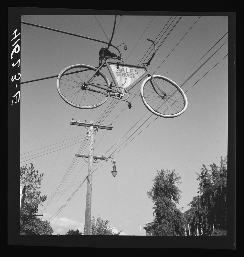[Untitled photo, possibly related to: Old bicycle used as a sign for a repair shop in Thompsonville, Connecticut]. Sourced…