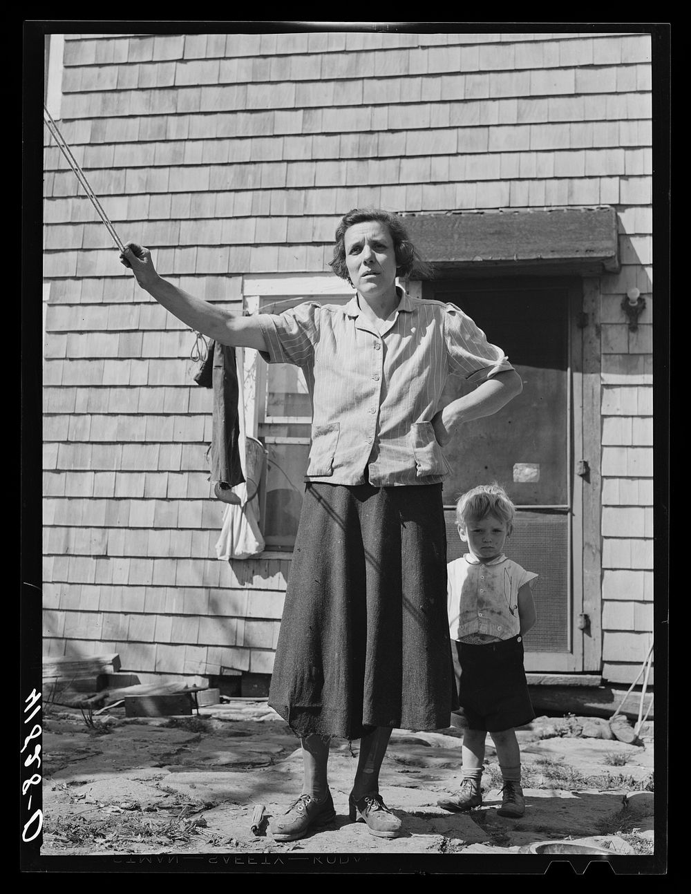 Mrs. Thomas Festa and one of her children. FSA (Farm Security Administration) client, Italian, on the back porch of her…