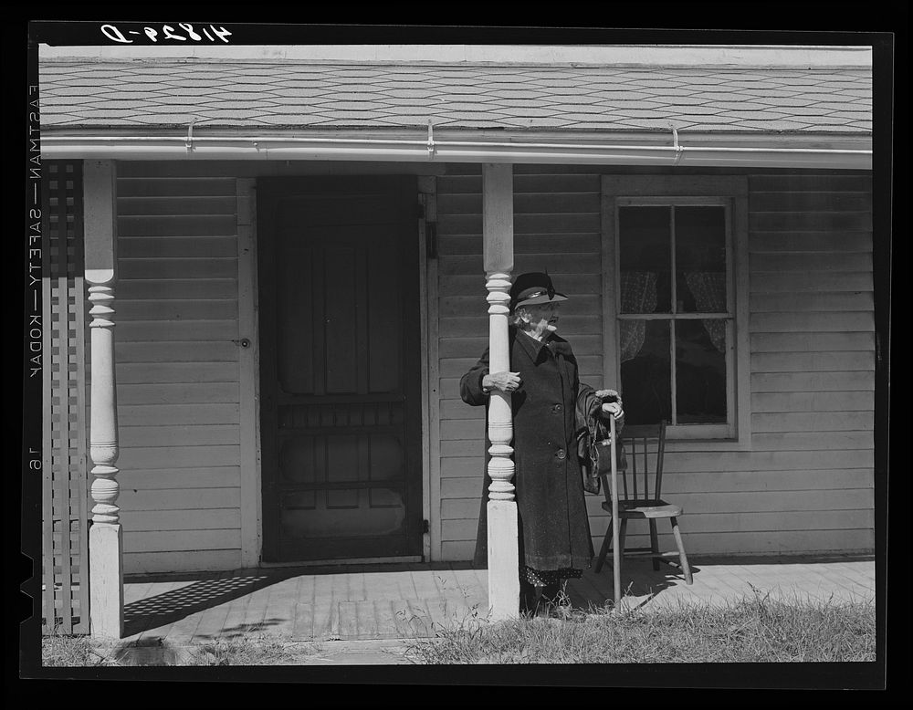 Old woman waiting for a bus in front of her house. Newtown, Connecticut. Sourced from the Library of Congress.