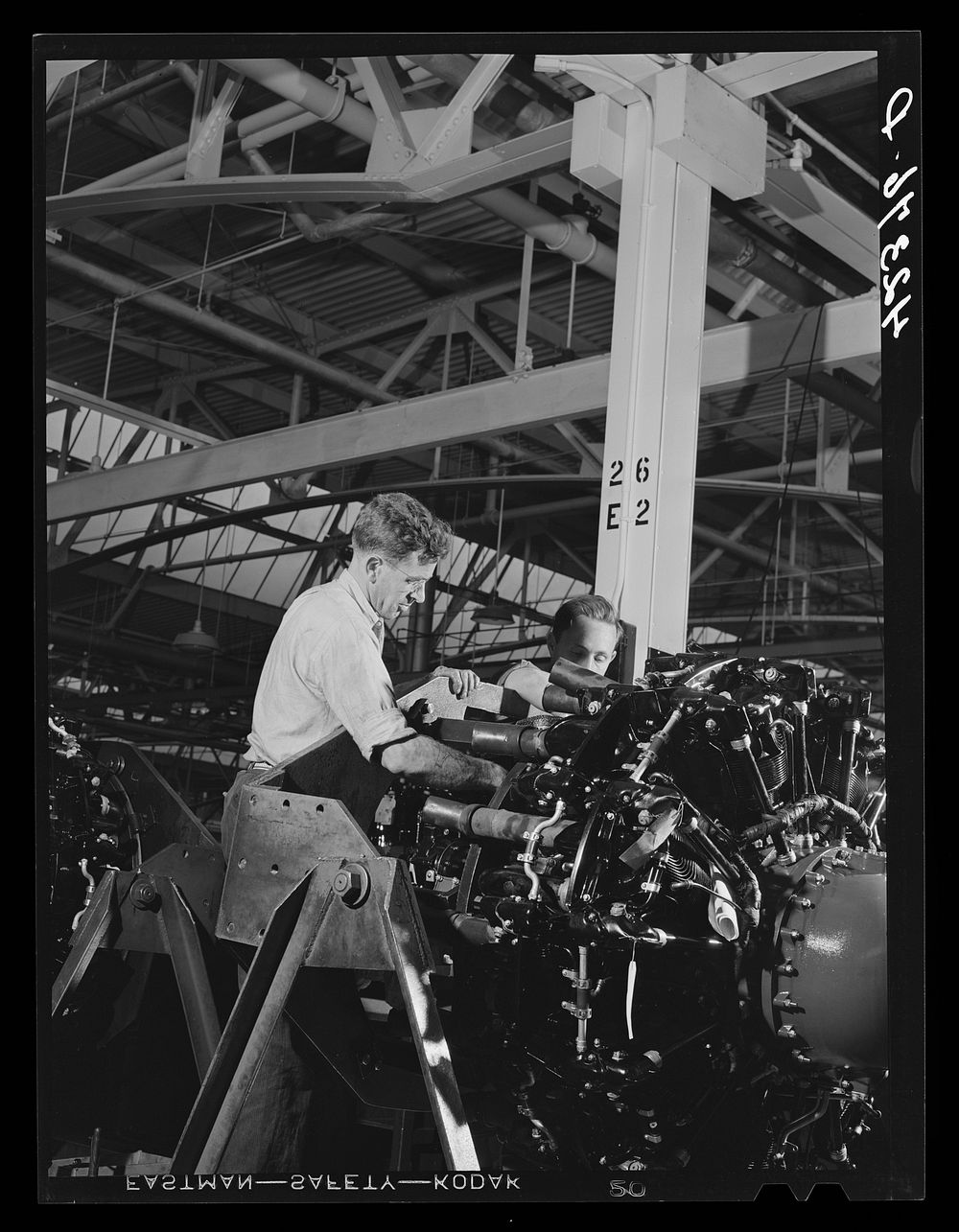 Working on the final assembly of Pratt and Whitney Aircraft motors at the plant in East Hartford, Connecticut. Sourced from…