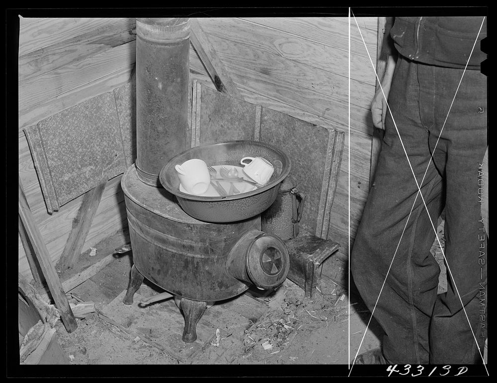 Washing dishes in a shack occupied by workers from Fort Bragg, North Carolina. Near Fayetteville. Sourced from the Library…