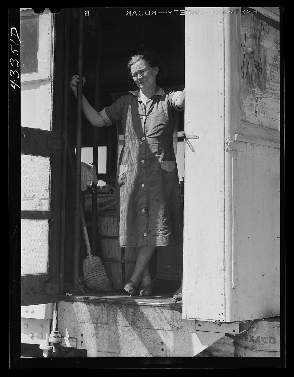 [Untitled photo, possibly related to: Woman living with her family of four in an old street car. Her husband is a watchman…