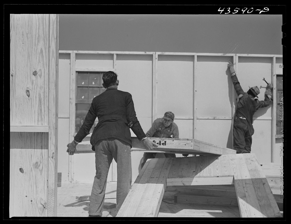 [Untitled photo, possibly related to: Getting up the walls on a prefabricated house being built by FSA (Farm Security…