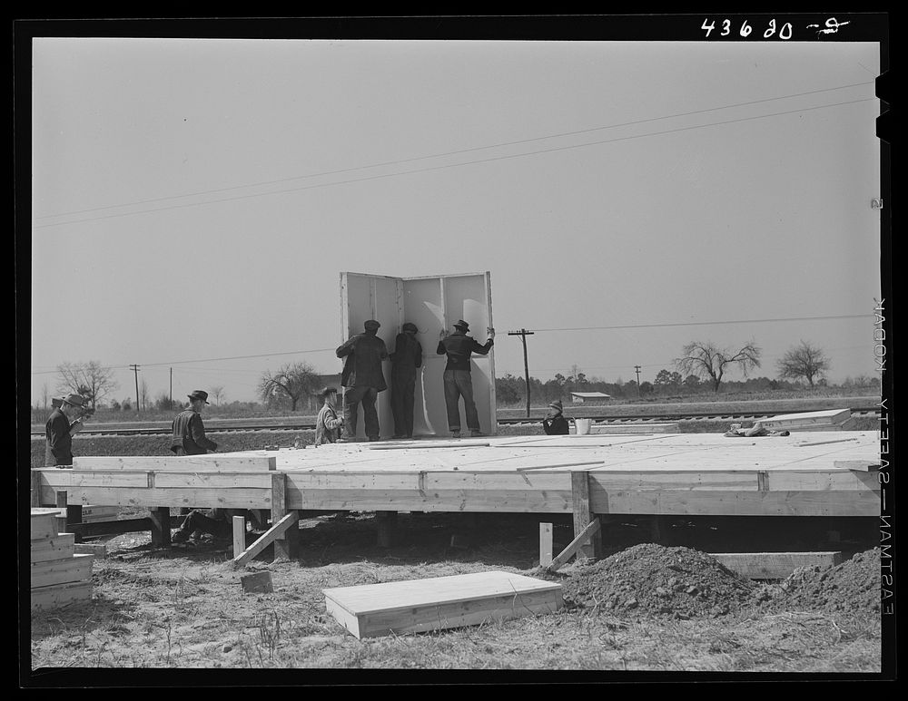 The first walls go up after the foundation has been built on prefabricated houses built by FSA (Farm Security…