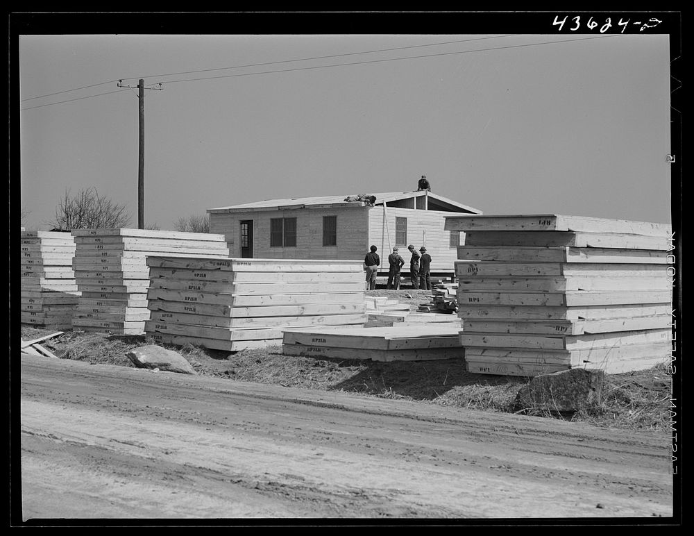 [Untitled photo, possibly related to: Building prefabricated houses for farmers who had to move out of the Camp Croft area.…