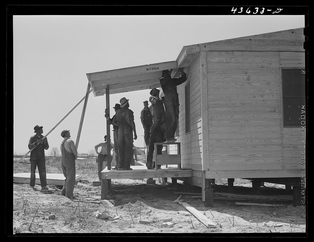 Putting the porch on a prefabricated house built near Pacolet, South Carolina by the FSA (Farm Security Administration) for…