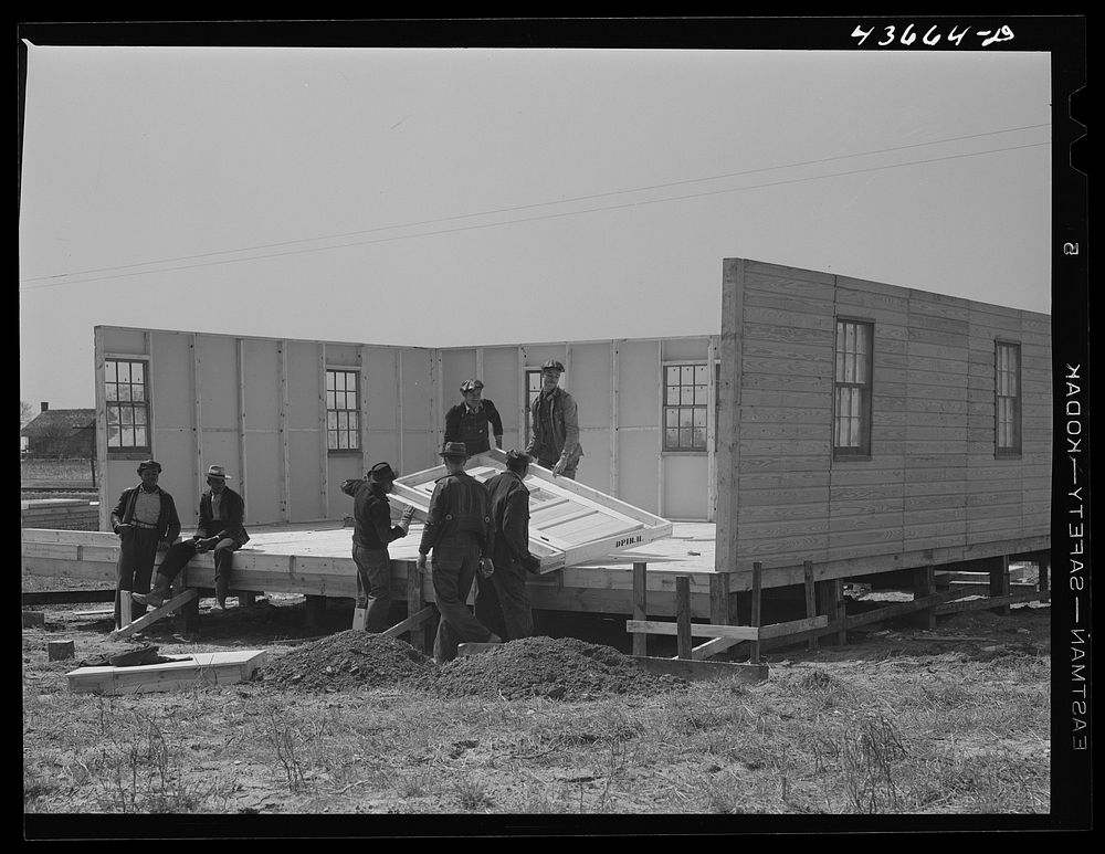 Assembling the fourth wall of a prefabricated house at the FSA (Farm Security Administration) project in Pacolet to house…