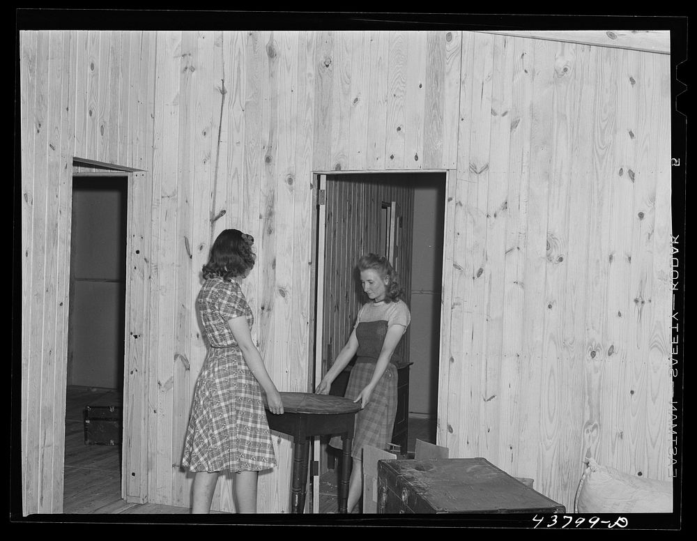 [Untitled photo, possibly related to: Arranging furniture at the new prefabricated house of the Lee family. Near Pacolet…