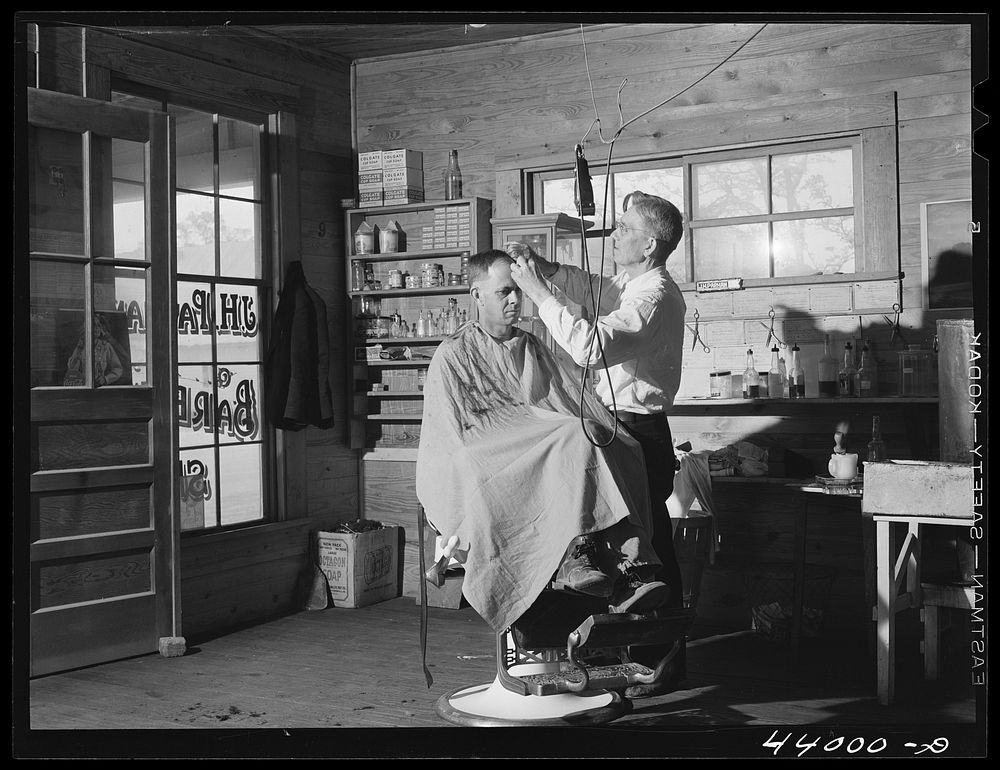 Mr. J. H. Parham, barber and notary public, in his shop in Centralhatchee, Heard County, Georgia. Sourced from the Library…