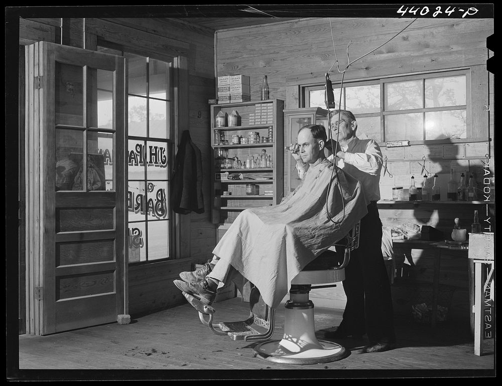 [Untitled photo, possibly related to: Mr. J. H. Parham, barber and notary public, in his shop in Centralhatchee, Heard…