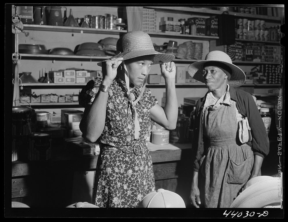 Trying on a new straw hat in Mr. M. W. Lipford's general store in Franklin. Heard County, Georgia. Sourced from the Library…