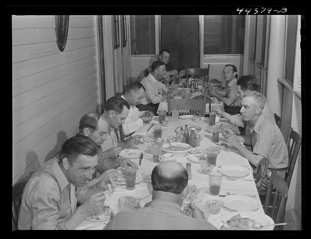 Workers from the powder plant having dinner at their boarding house. Childersburg, Alabama. Sourced from the Library of…