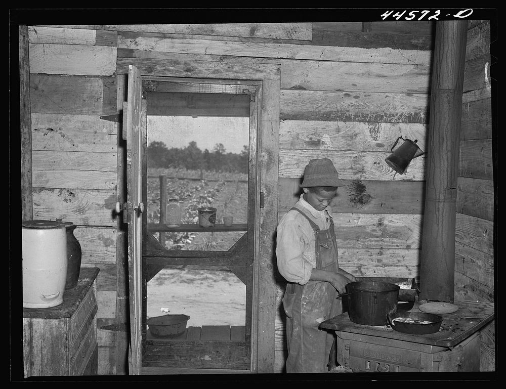 One of the children of R. L. Smith, preparing dinner for the rest of the family. FSA (Farm Security Administration)…