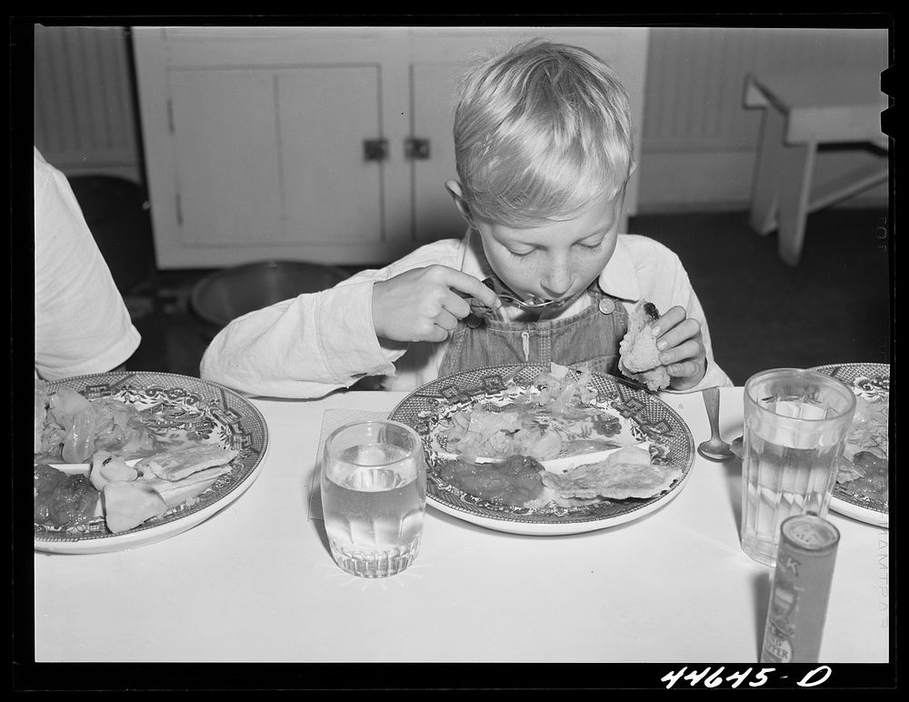 Eating a five-cent hot lunch at the Woodville public school. Greene County, Georgia. Sourced from the Library of Congress.