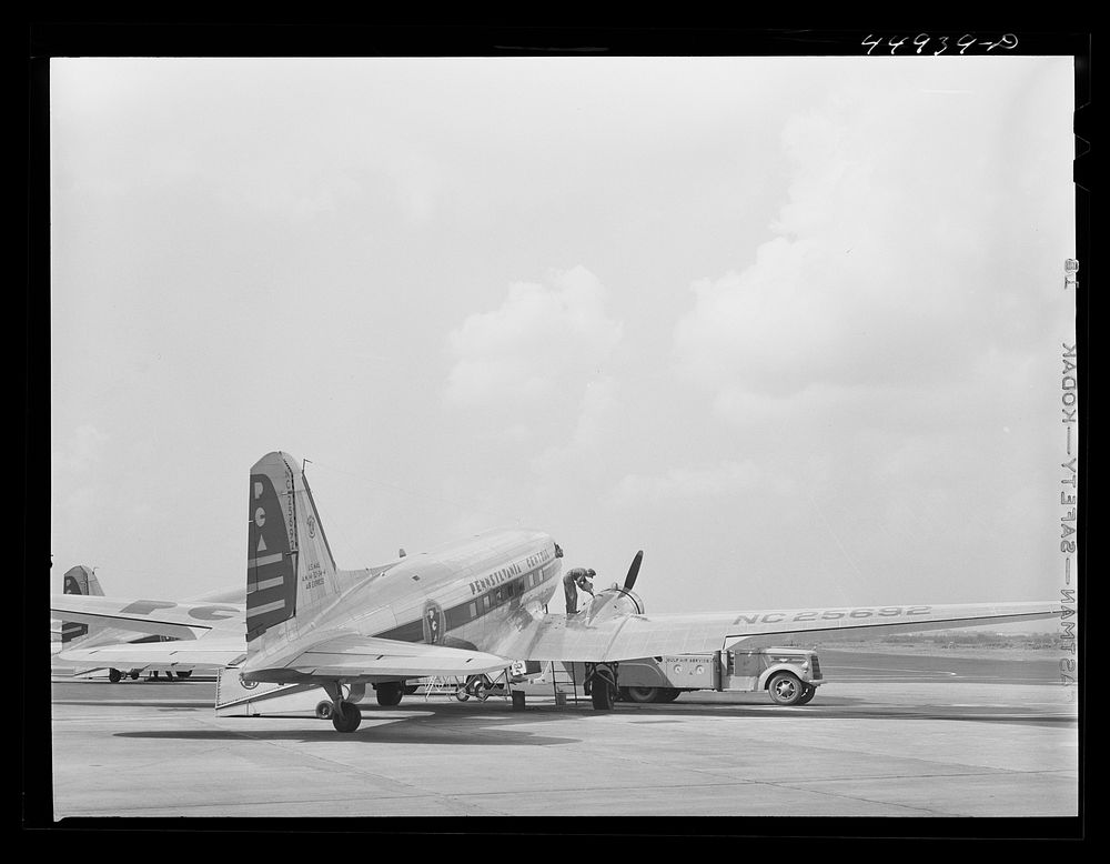 [Untitled photo, possibly related to: Oil for the engine of an airliner preparatory to takeoff. Municipal airport…