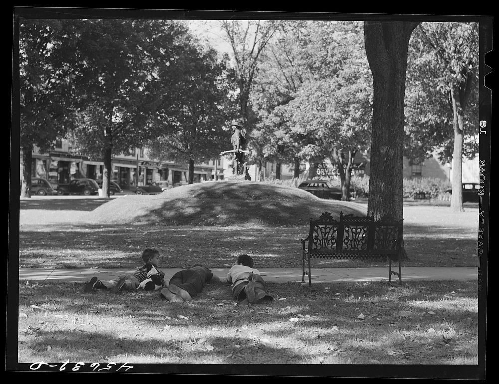 [Untitled photo, possibly related to: Boys lounging in the square in Enosburg Falls, Vermont]. Sourced from the Library of…