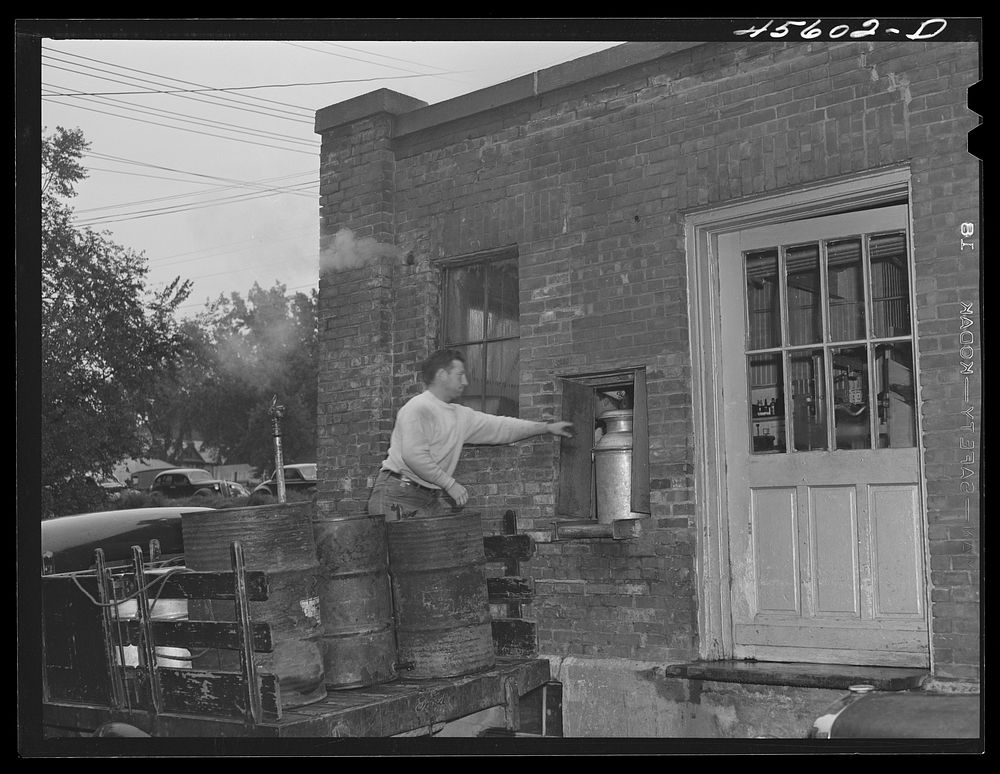 [Untitled photo, possibly related to: Farmer getting his empty milk cans back at the Burlington cooperative milk bottling…