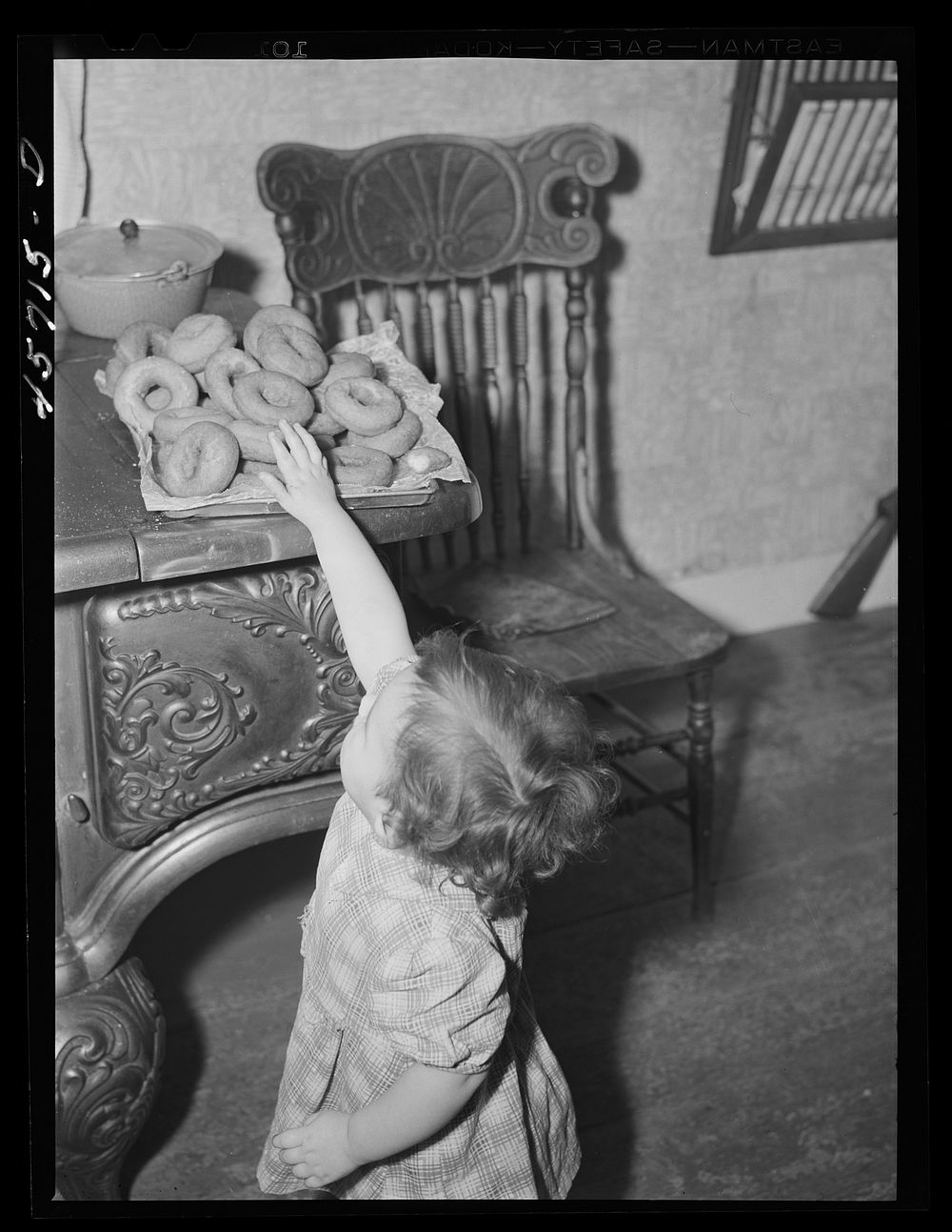 "Sister" reaching for some doughnuts at the Gaynor home near Fairfield, Vermont. Sourced from the Library of Congress.