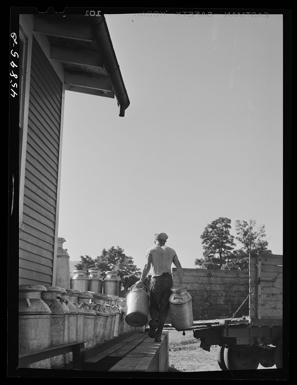 Unloading milk cans from a farmer's truck at the United Farmers' Cooperative Creamery. Sourced from the Library of Congress.