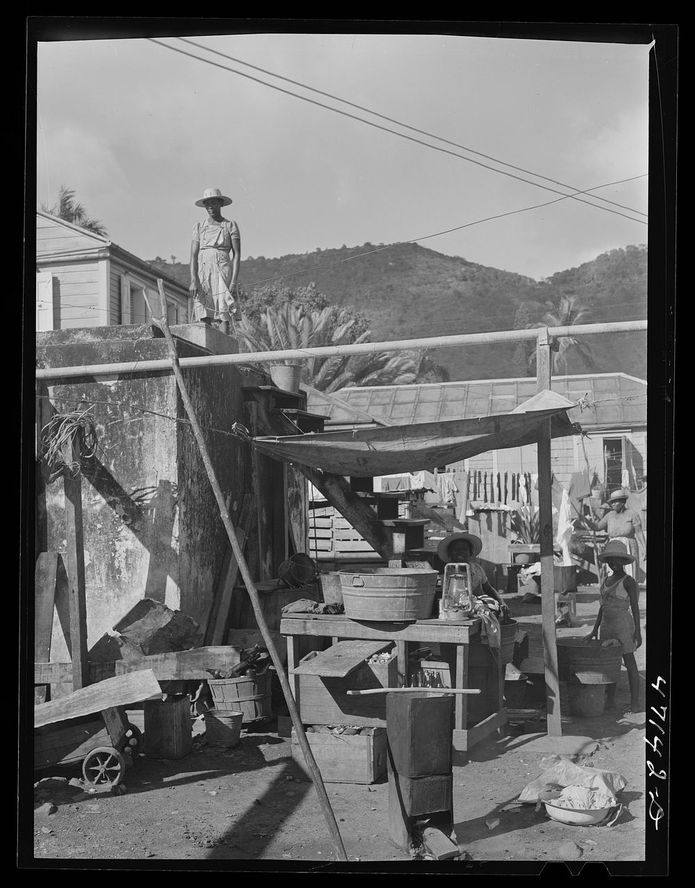 Charlotte Amalie, Saint Thomas Island, Virgin Islands. Getting water out of a cistern on a side street. Sourced from the…