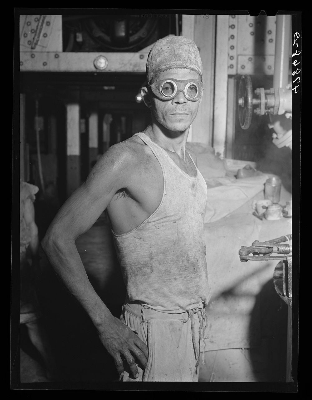 Ensenada, Puerto Rico. Laborer wearing goggles as protection against the fumes and vapors of hot molasses at the South…