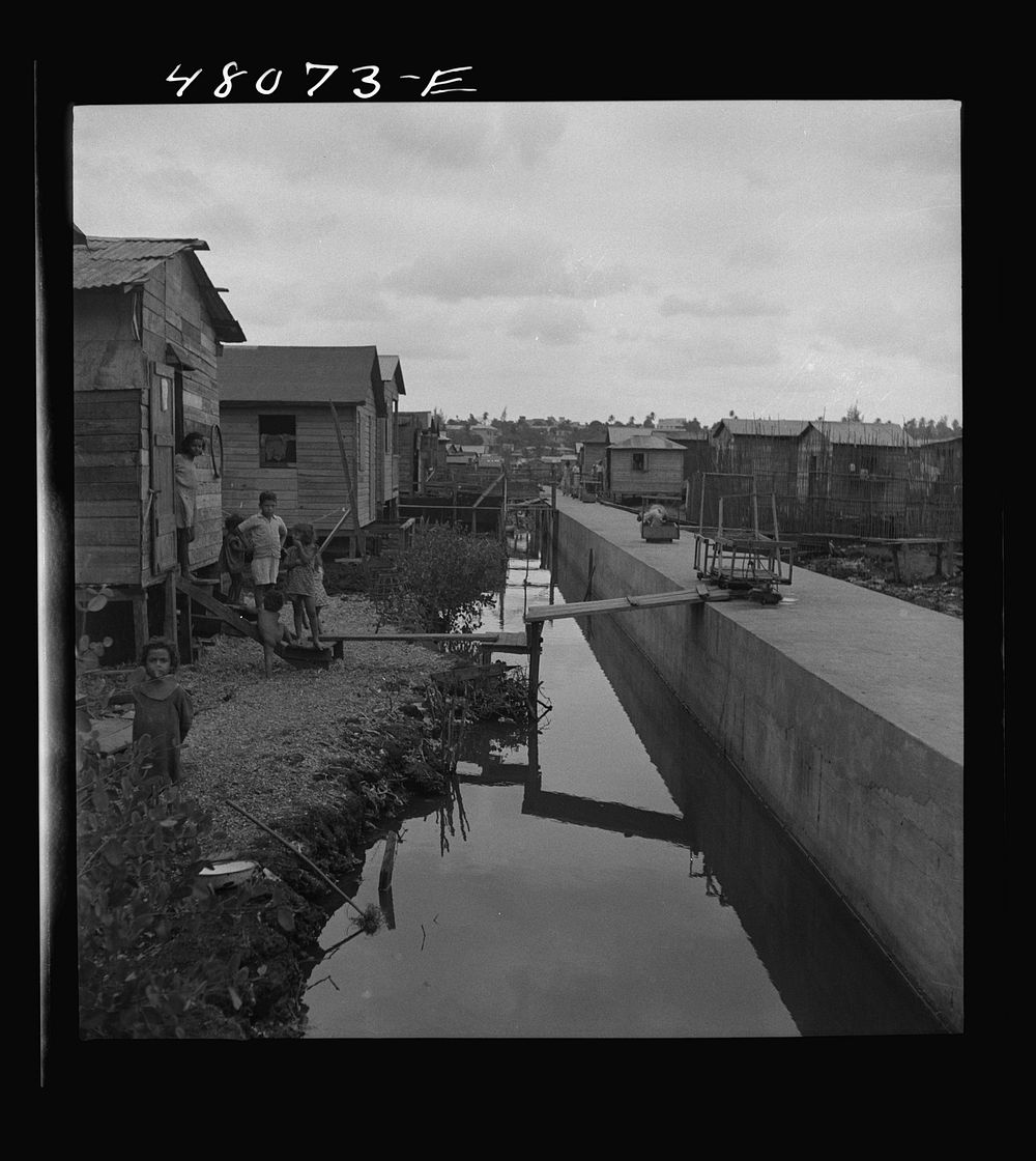 San Juan, Puerto Rico. In the huge slum area known as "El Fangitto." The concrete causeway is the sewer line from the…