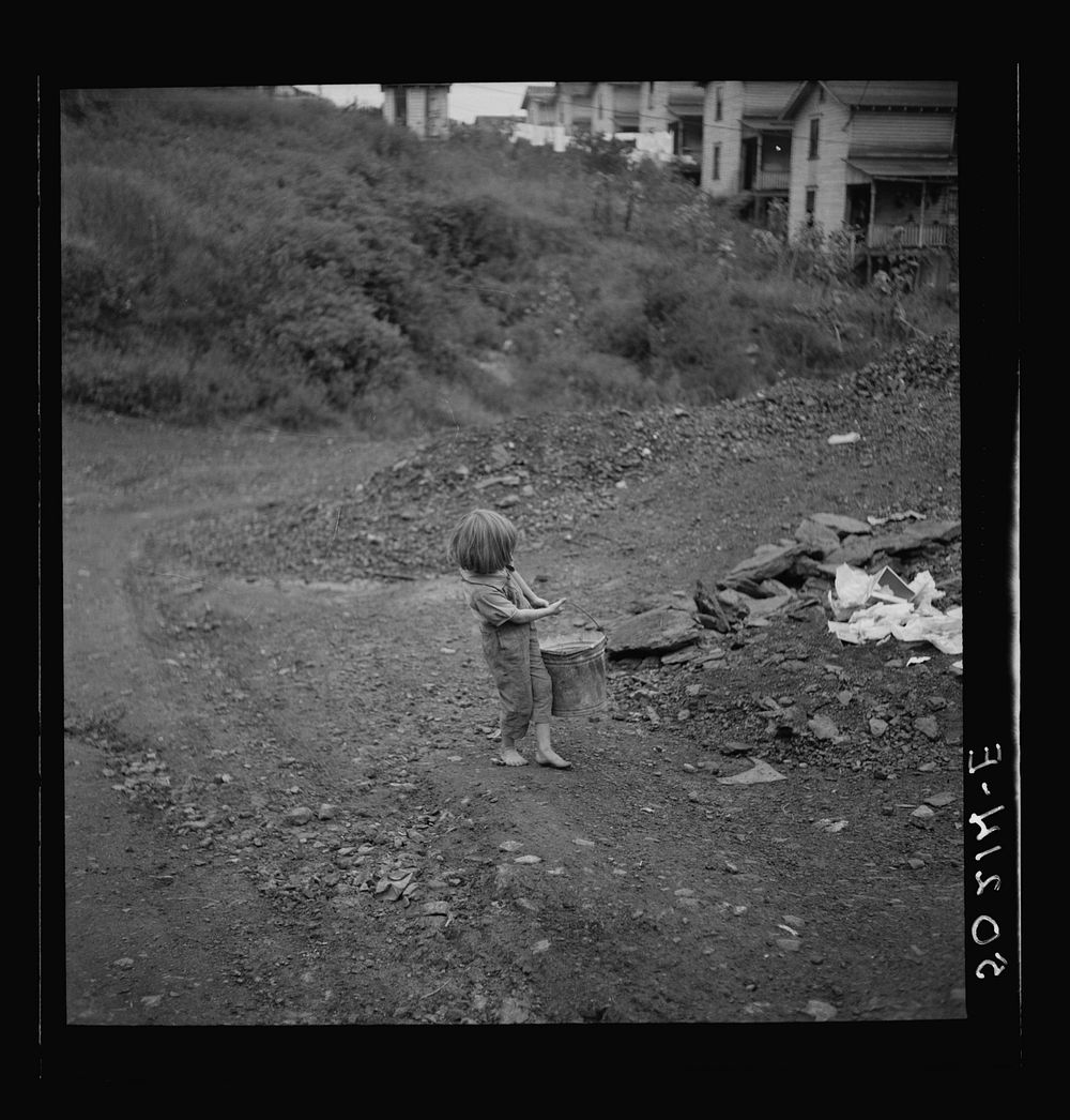 [Untitled photo, possibly related to: Child of miner carrying home coal she picked out of old slate pile down the hill.…