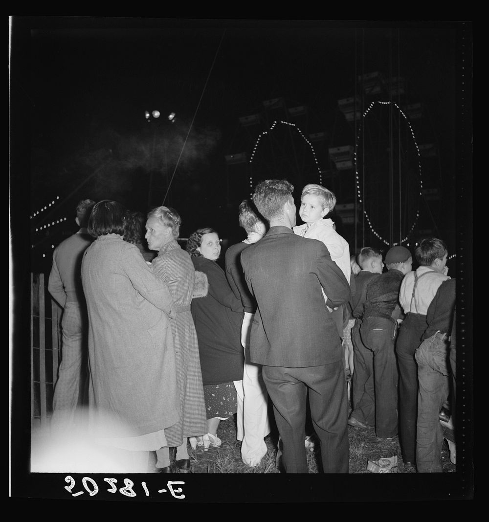 Coal miners and their families all turn out for carnival, once a year.  Granville, West Virginia. They are watching the…