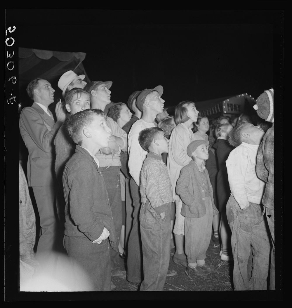 Coal miners and their families watching the girls and women's skirts blow up in the "crazy boat" at the outdoor carnival.…
