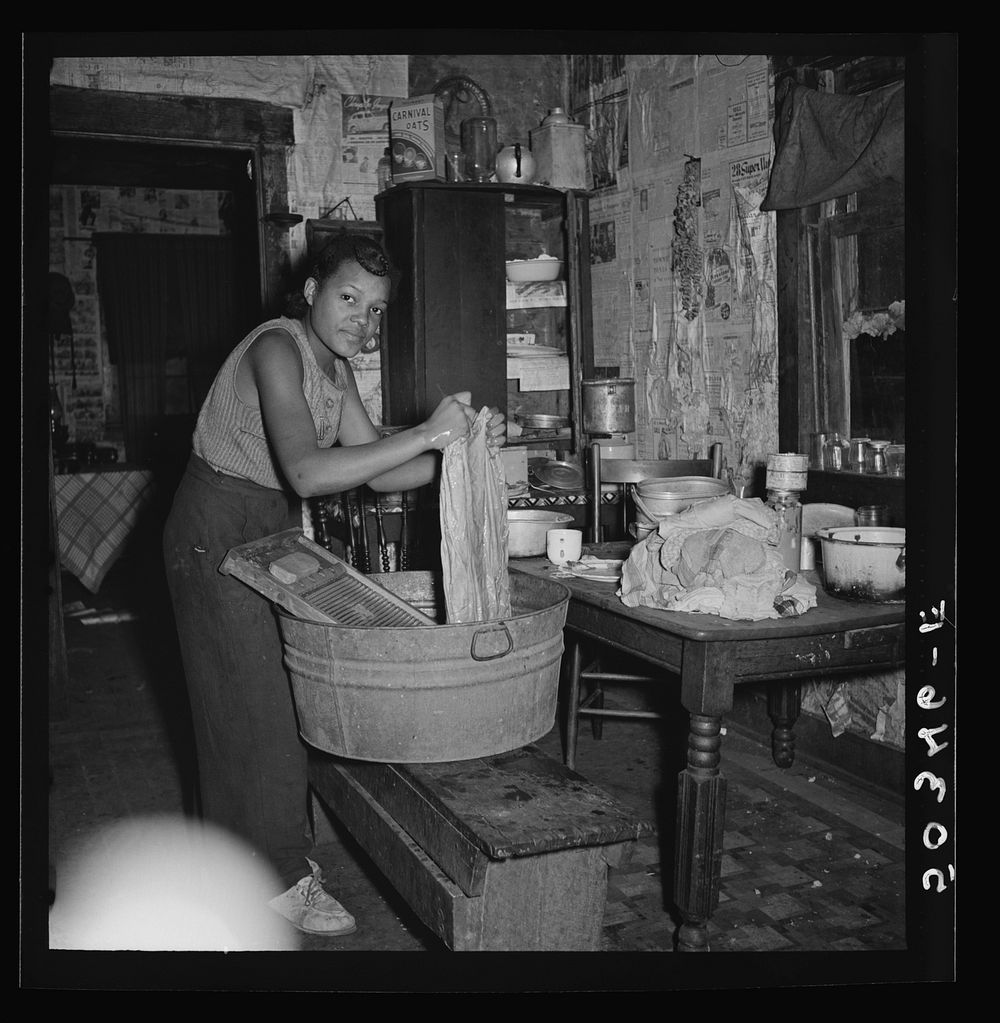 Coal miner's daughter doing the family wash. All the water must be carried from up the hill. Bertha Hill, West Virginia.…