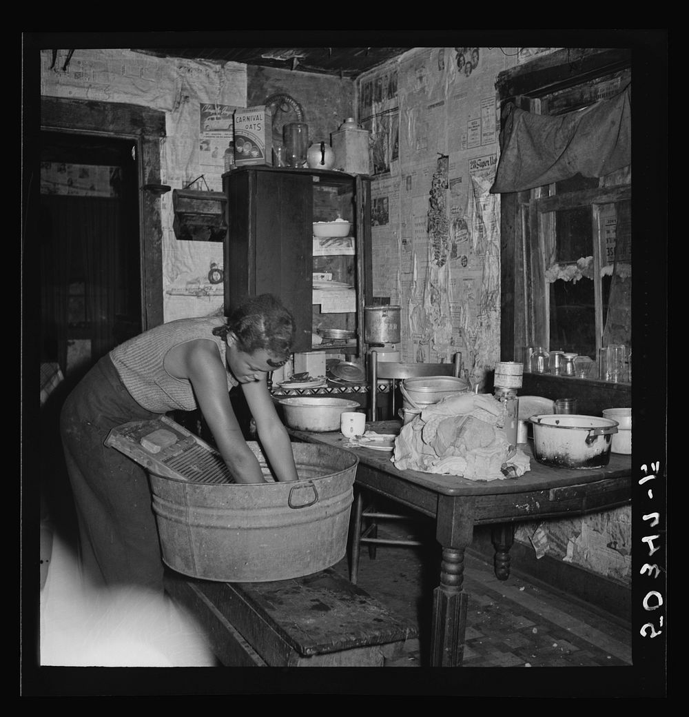[Untitled photo, possibly related to: Coal miner's daughter doing the family wash. All the water must be carried from up the…
