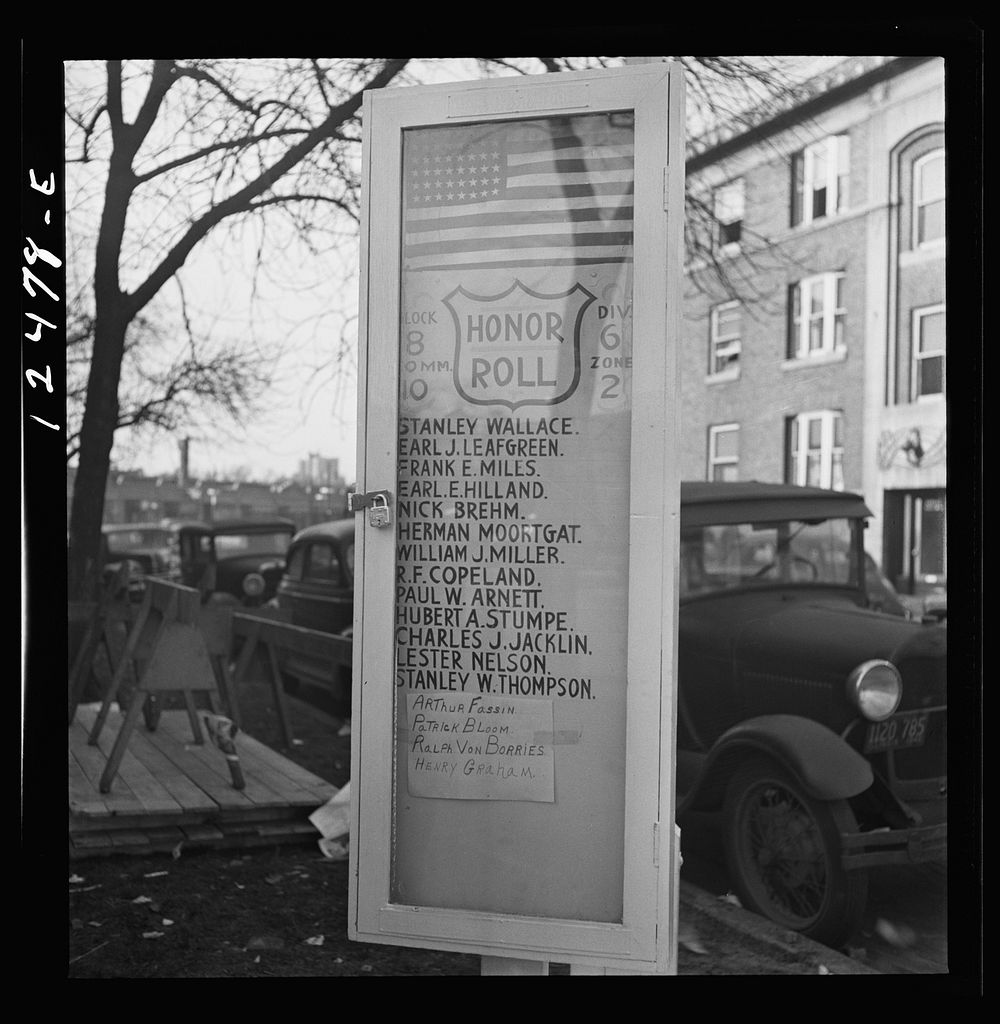 Chicago (north), Illinois. A list of men in the block who are in the armed forces, posted on a flag pole erected by the…