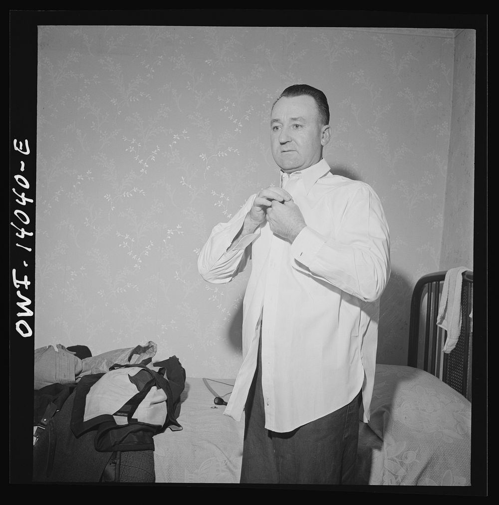 Clinton, Iowa. Clarence Averill, brakeman, washing and changing his clothes. He keeps a clean suit at the rooming house all…