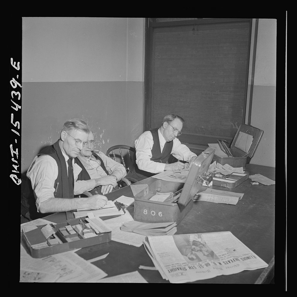 Chicago, Illinois. Conductors checking on their recepits and tickets in their locker and rest room in Union Station. Sourced…