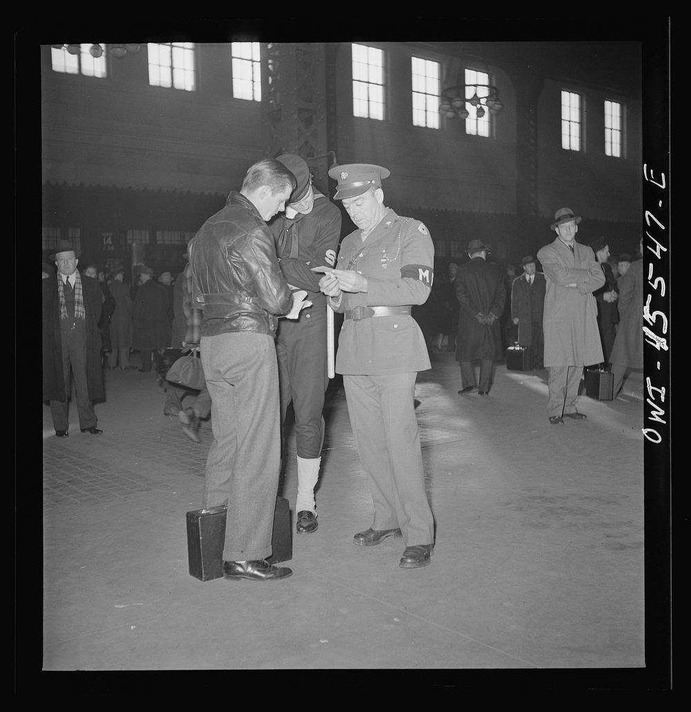 Chicago, Illinois. Military and Naval police help a recruit on his way at the Union Station. Sourced from the Library of…