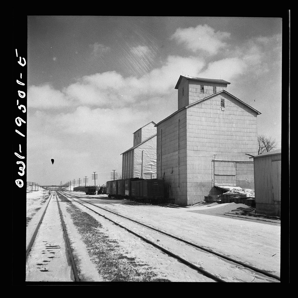 Ransom, Illinois. Passing farmers' grain elevators on a siding along the Atchison, Topeka and Santa Fe Railroad between…
