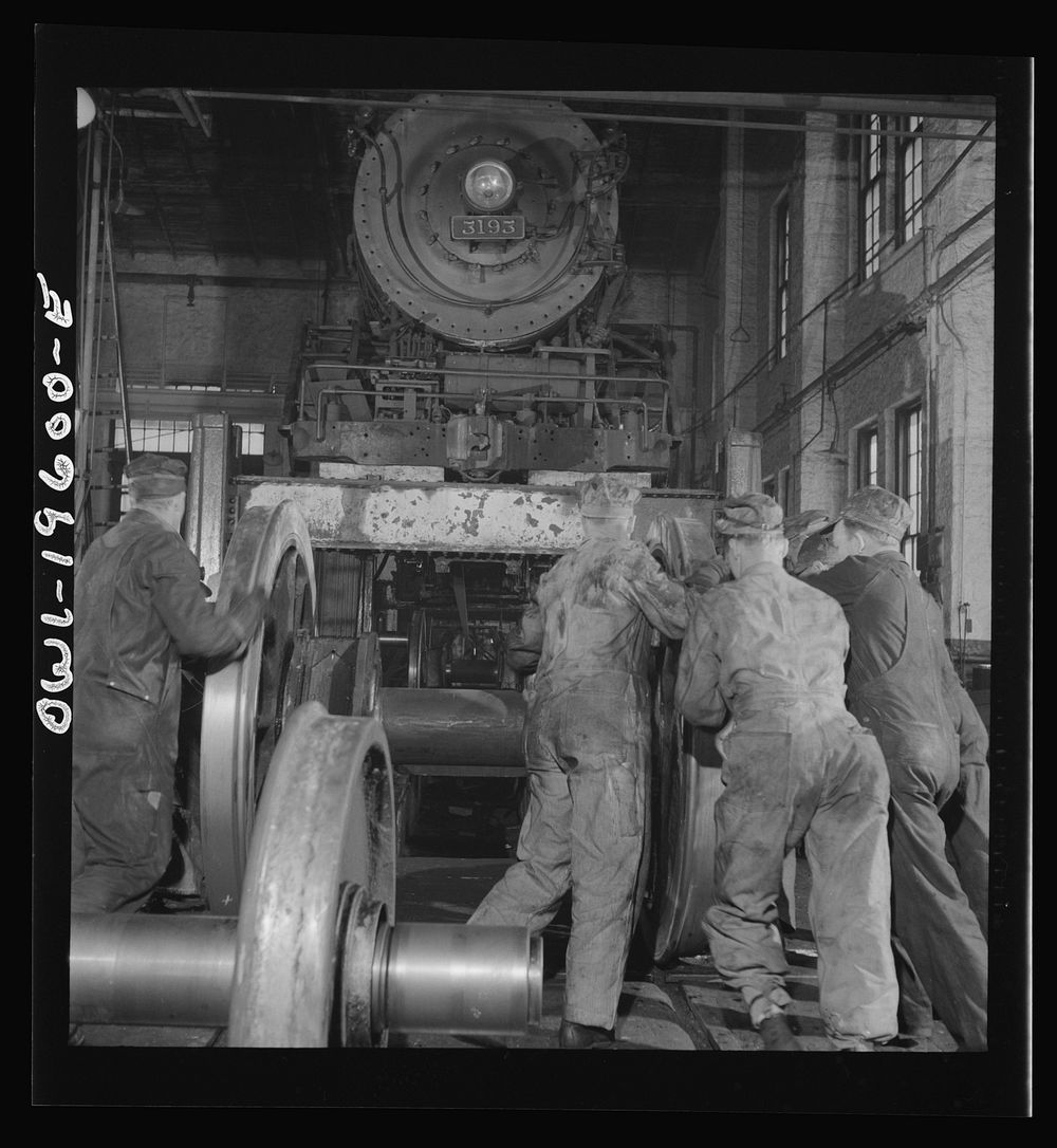 Fort Madison, Iowa. Wheeling an engine in the Shopton locomotive shops of the Atchison, Topeka, and Santa Fe Railroad.…