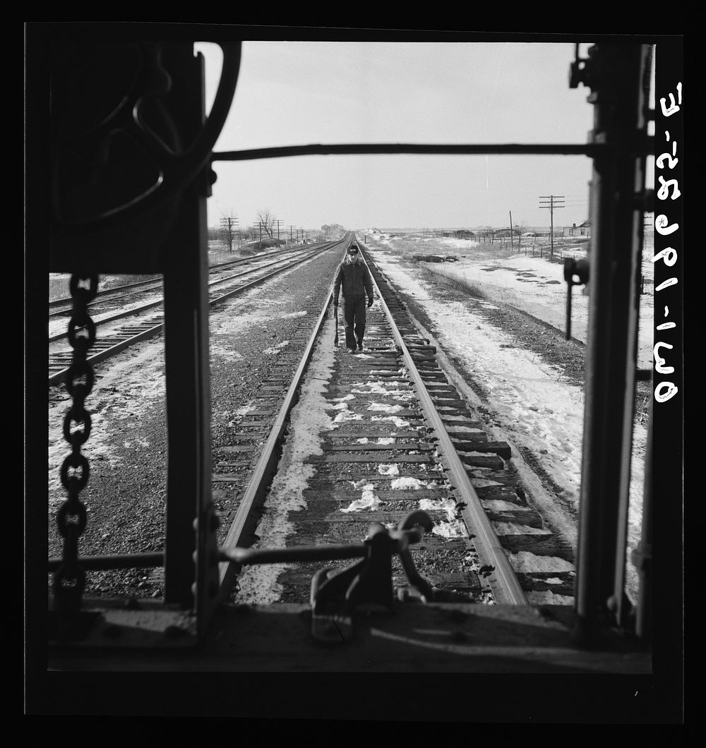 Baring, Missouri. A flagman returning to a train on the Atchison, Topeka, and Santa Fe Railroad, as it is about to start…
