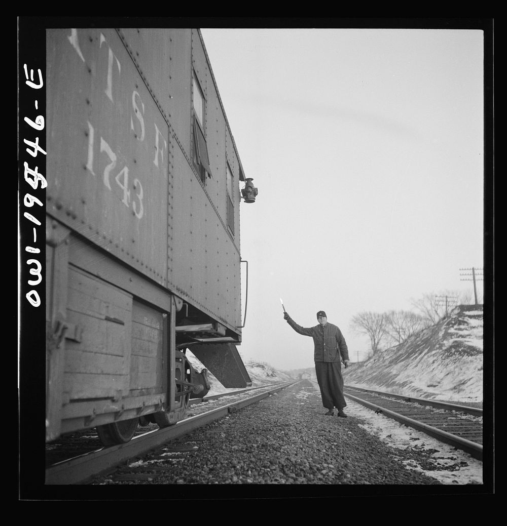 Dahinda (vicinity), Illinois. The flagman gives the highball sign as the train is ready to start again on the Atchison…
