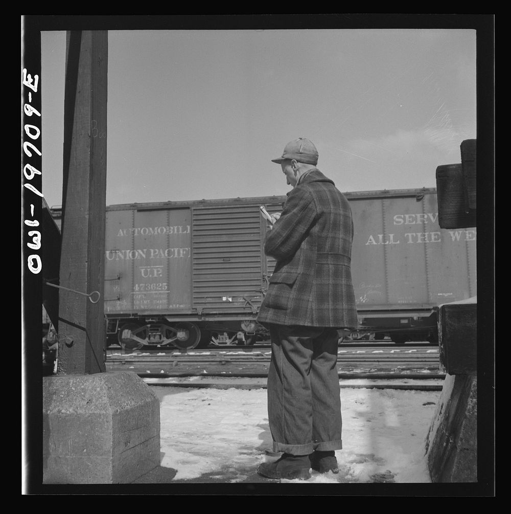 Argentine, Kansas. A yard clerk making notes of car numbers in the Atchison, Topeka, and Santa Fe Railroad yard. Sourced…