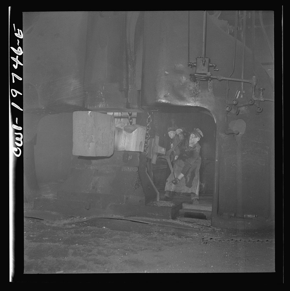 [Untitled photo, possibly related to: Topeka, Kansas. Workmen manipulating a hot forging which is being hammered under a…
